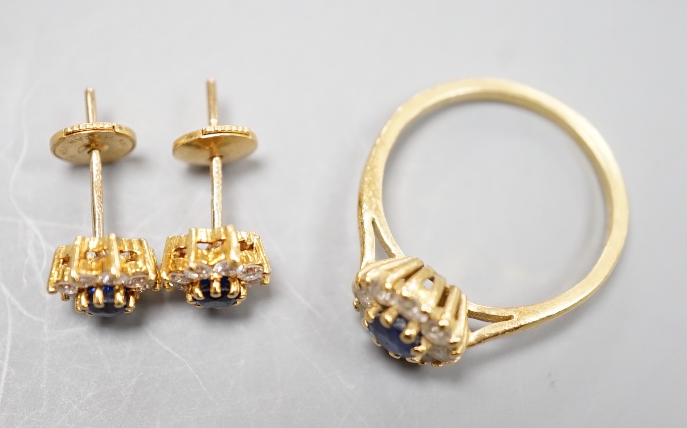 A modern 18ct gold, sapphire and diamond set circular cluster ring, size L and a pair of matching earrings, gross weight 4.6 grams.